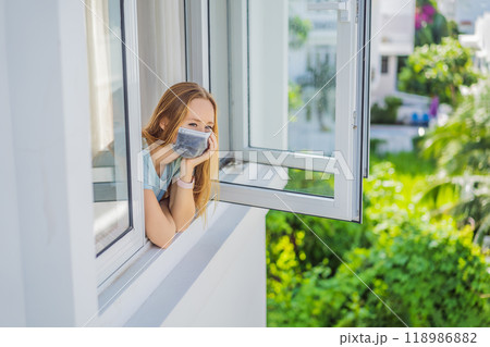Extremly tired woman looking out the window, home alone. self-isolation at home, quarantine due to pandemic COVID 19. Mental health problems in self-isolation at home, quarantine, isolation, stay at 118986882