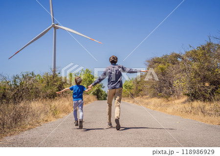 Alternative energy, wind farm and happy time with your family. Happy father on the road with his son on vacation and escape to nature. Father and son waving their arms like a windmill 118986929