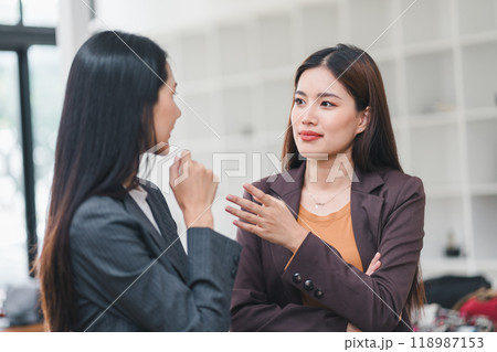 Two Asian Businesswomen Gossiping in the Office. 118987153