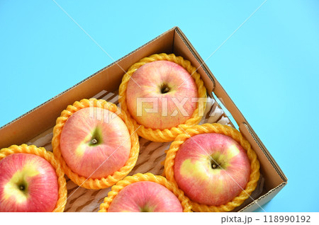 beautiful pink apple in the box on blue background beautiful pink apple in the box on blue background 118990192