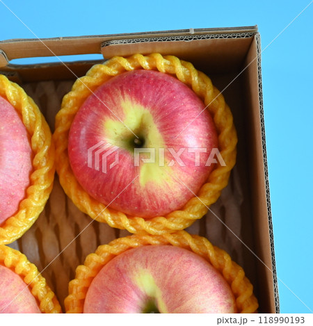 beautiful pink apple in the box on blue background beautiful pink apple in the box on blue background 118990193
