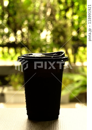 Black plastic glass on a wooden table Black plastic glass on a wooden table 118991921