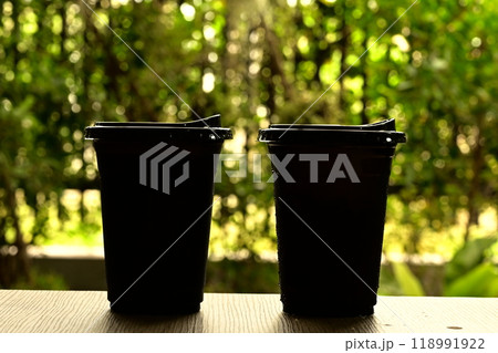 Black plastic glass on a wooden table Black plastic glass on a wooden table 118991922