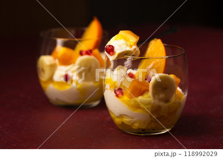 dessert with fruits in transparent glasses on a burgundy background dessert with fruits in transparent glasses on a burgundy background 118992029