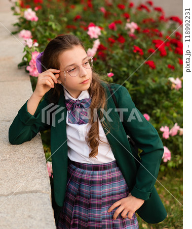 Young girl in school uniform looking thoughtfully Young girl in school uniform looking thoughtfully 118992231