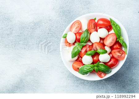 Basil leaves , cherry tomatoes and mozzarella cheese . In bowl food photography 118992294