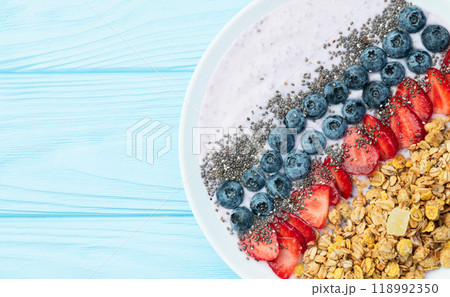 Healthy breakfast . Yogurt with berries ( strawberry , raspberry , blueberry , blackberry ) , granola and chia seeds . Top view Healthy breakfast . Yogurt with berries ( strawberry , raspberry , blueberry , blackberry ) , granola and chia seeds . Top view 118992350