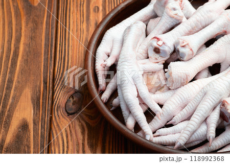 Raw chicken foot ( paws ) Top view on rustic background Raw chicken foot ( paws ) Top view on rustic background 118992368