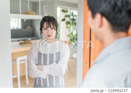 帰宅した夫を不機嫌な顔で見つめる妻・若いアジア人女性 118993217