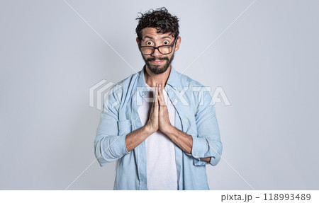 Pleading person asking for a favor, People with a pleading expression asking for a favor. Man putting his hands together asking for a favor 118993489