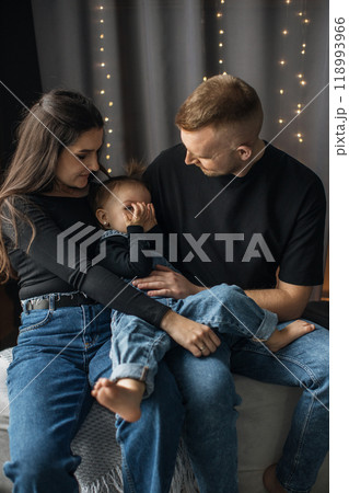 Loving family moment with parents and child on sofa Loving family moment with parents and child on sofa 118993966