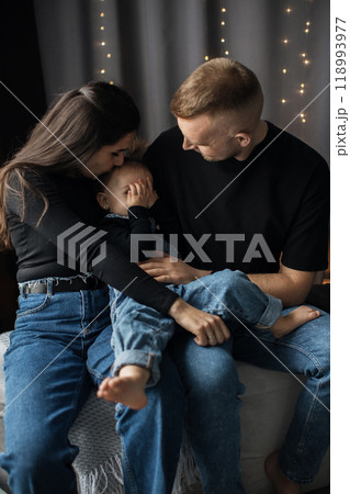 Loving family moment with parents and child on sofa Loving family moment with parents and child on sofa 118993977