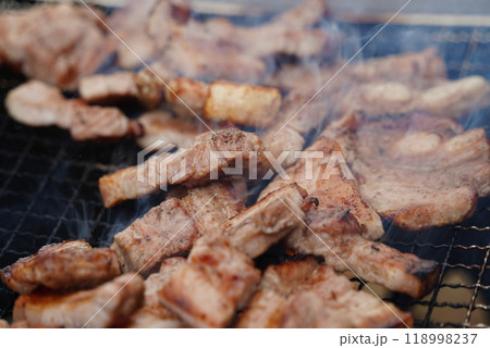 Close-up of pork belly being grilled on a charcoal grill. 118998237