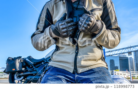 バイク用胸部プロテクターを準備する男性ライダー バイク用胸部プロテクターを準備する男性ライダー 118998773