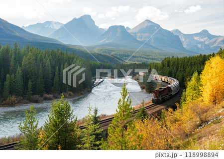 Banff National Park Bow river autumn landscape. Alberta, Canada. Freight train at Morant's Curve railway. Canadian Rockies beautiful natural scenery. 118998894