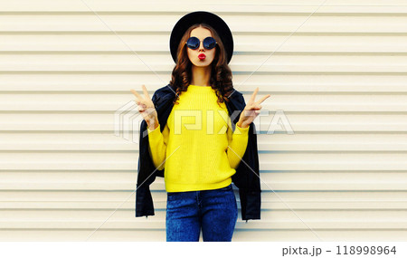 Fashionable stylish young woman posing in black jacket with backpack on white background 118998964