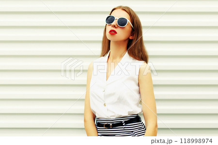 Portrait of beautiful young woman model posing wearing sunglasses on white background Portrait of beautiful young woman model posing wearing sunglasses on white background 118998974