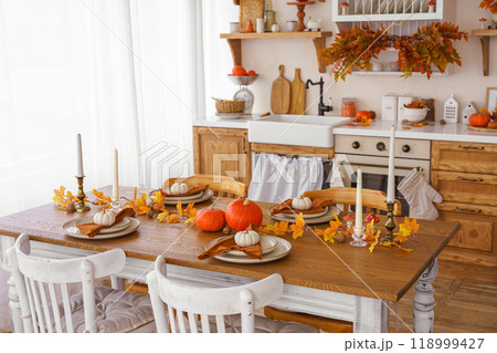 Kitchen, dinning table decorated with pumpkin, candle and leaves for Halloween, Thanksgiving day 118999427