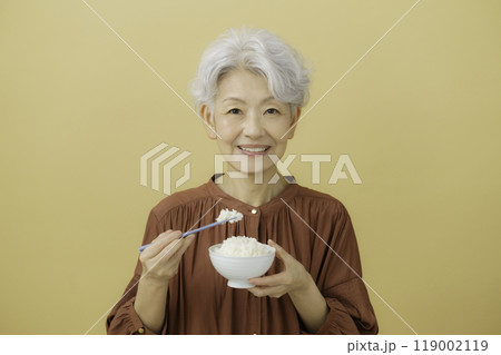 ご飯の入ったお茶碗と箸を持つ白髪のシニア女性 119002119