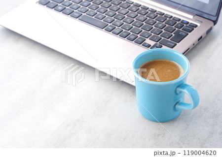 オフィスでデスクワークの合間に、牛乳をたっぷり入れたコーヒーのカフェ・ラッテを飲む 119004620