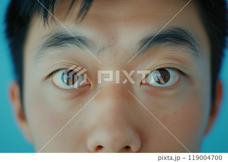 Close up of a young Chinese man showcasing expressive features and casual style. Close up of a young Chinese man showcasing expressive features and casual style. 119004700