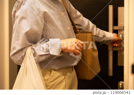 マンションに帰宅して玄関の戸締りをするシニア女性 119006541