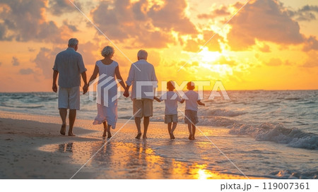 Multigenerational family enjoying a sunset walk on the beach, grandparents and kids leading the way 119007361