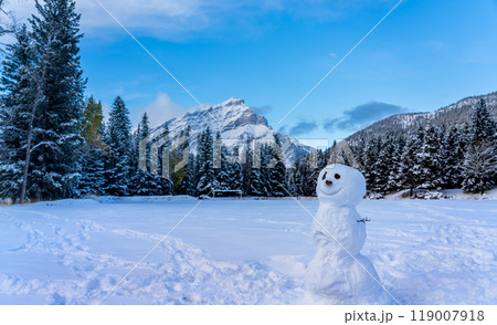 A smiling snowman in the snowy playground. Cascade Mountain and trees in the background. Banff National Park, Canadian Rockies. A smiling snowman in the snowy playground. Cascade Mountain and trees in the background. Banff National Park, Canadian Rockies. 119007918