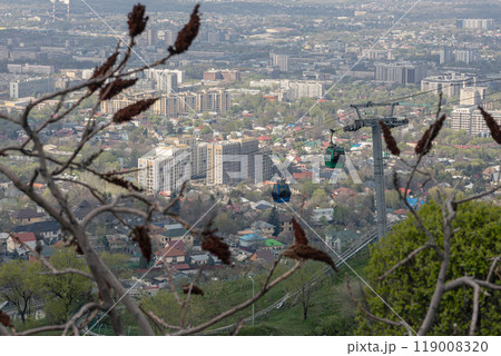 Aerial lift to Kok Tobe hill in Almaty, Kazakhstan. Cable car with two cabins, against the backdrop of the city 119008320