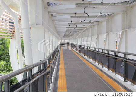 Pedestrian pathway or corridor or hallway between train station and other building. Pedestrian pathway or corridor or hallway between train station and other building. 119008514