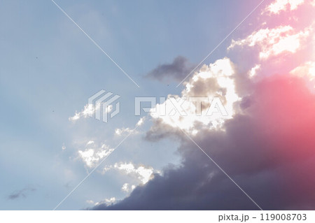 White clouds in bright sunlight. Revival of day. Clouds in glare of sun. 119008703