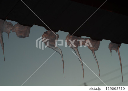 Meltwater flows from the roof . Icicles on the roof of the house. Beautiful ice in winter. 119008710