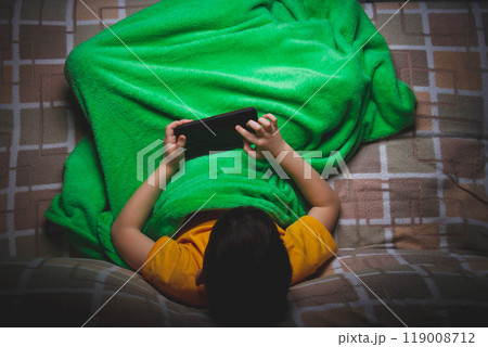 Phone in hands of child. Little boy playing mobile games on smartphone. Hand closeup. 119008712