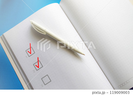 The pen rests on an unfolded notebook. 119009003