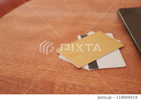 A collection of Credit Cards elegantly displayed on a Wooden Table along with a Laptop A collection of Credit Cards elegantly displayed on a Wooden Table along with a Laptop 119009419