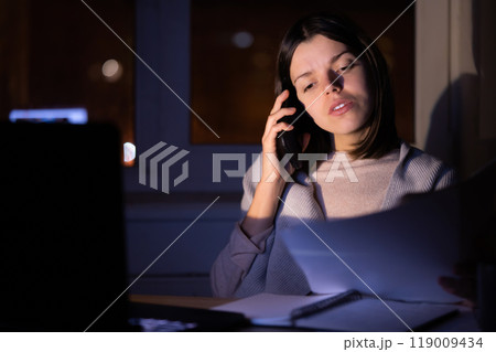 Girl is working on a laptop at night at home. Girl is working on a laptop at night at home. 119009434