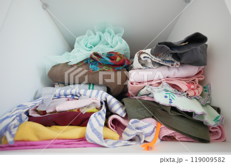 Wellorganized closet with neatly folded clothes and textiles for a tidy, minimalistic look Wellorganized closet with neatly folded clothes and textiles for a tidy, minimalistic look 119009582