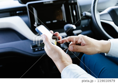 車内でスマホを操作する作業服の男性 車内でスマホを操作する作業服の男性 119010979
