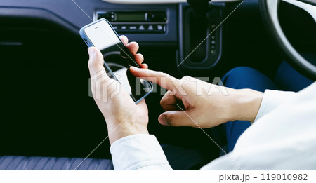 車内でスマホを操作する作業服の男性 車内でスマホを操作する作業服の男性 119010982