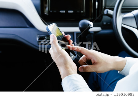 車内でスマホを操作する作業服の男性 車内でスマホを操作する作業服の男性 119010985