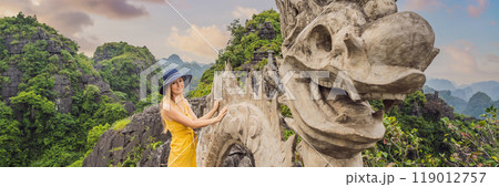 BANNER, LONG FORMAT Woman tourist on background of amazing huge dragon statue at limestone mountain top near Hang Mua view point at foggy morning. Popular tourist attraction at Tam Coc, Ninh Binh BANNER, LONG FORMAT Woman tourist on background of amazing huge dragon statue at limestone mountain top near Hang Mua view point at foggy morning. Popular tourist attraction at Tam Coc, Ninh Binh 119012757