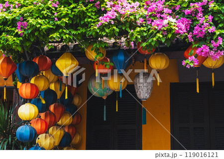 Colorful silk Chinese lanterns decorate the wall of a house for a holiday in old town in Hoi An in Asia 119016121
