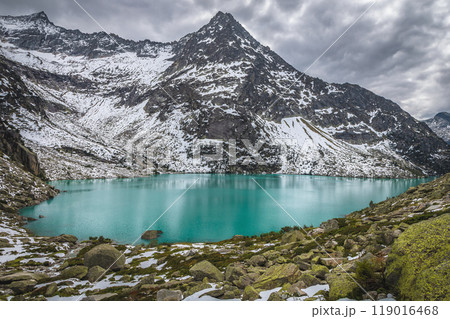 Turquoise Gelmersee lake and snowy mountains, Grimsel Pass, Switzerland 119016468
