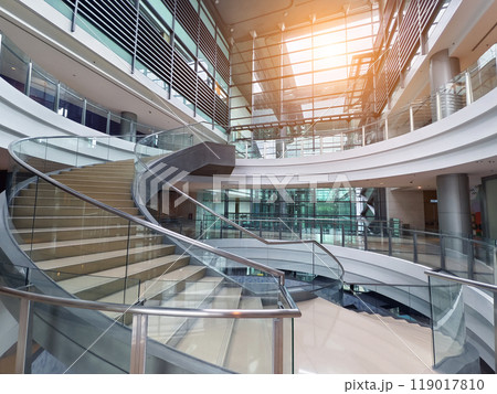 A beautifully designed spiral staircase in a modern building with glass railing 119017810