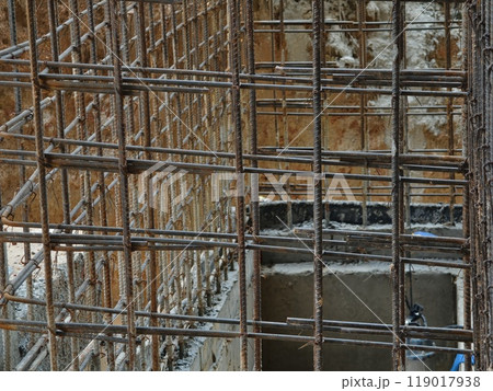 A construction site displaying a reinforced concrete foundation with steel rebar A construction site displaying a reinforced concrete foundation with steel rebar 119017938