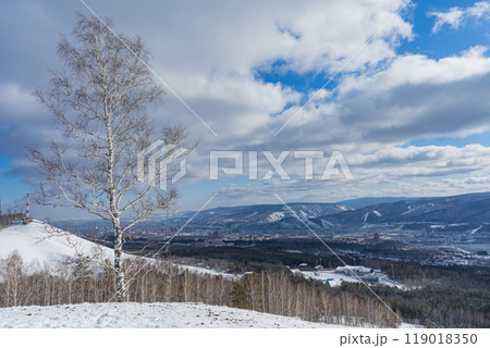 Siberian nature in Krasnoyarsk city, Russia. Yenisei river, hills and trees. Winter natural landscape, blue sky clouds Siberian nature in Krasnoyarsk city, Russia. Yenisei river, hills and trees. Winter natural landscape, blue sky clouds 119018350