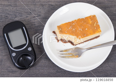 Glucometer and sweet cheesecake. Measuring and sugar level control during diabetes 119018850