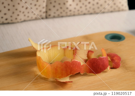 Apple peel on wooden board on kitchen at home, woman peels apple. 119020517