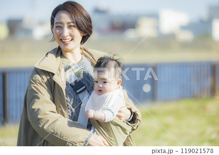 冬にお散歩する赤ちゃんを抱っこするお母さん　　 119021578