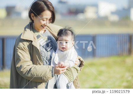冬にお散歩する赤ちゃんを抱っこするお母さん　　 119021579